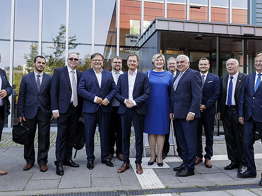 The German-Czech delegation stands in front of the entrance to the Blue Box on the Görlitz campus for a group photo.