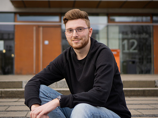 Johannes Krutz sits on the landing in front of the canteen.