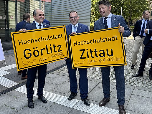 Ursu, Kratzsch and Zenker with the town entrance signs in their hands