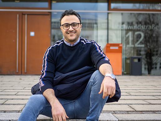 Ali Al Hamad sits on the staircase in front of the Zittau canteen.