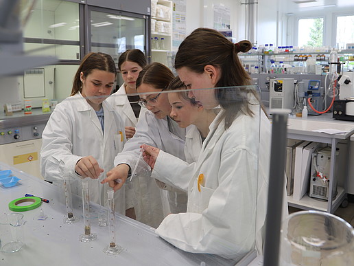 Pupils in the chemistry lab working with measuring beakers.