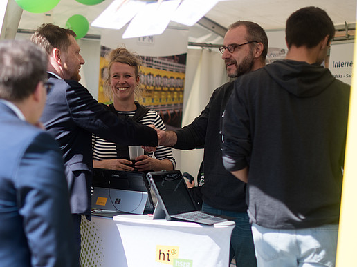 The Minister President and Vice President shake hands at the HSZG stand.