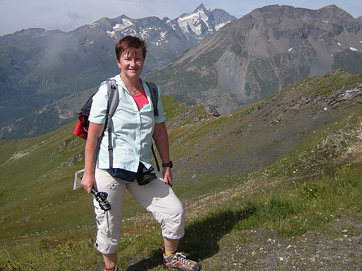 Prof. Spangenberg in a meadow. High mountains can be seen in the background.