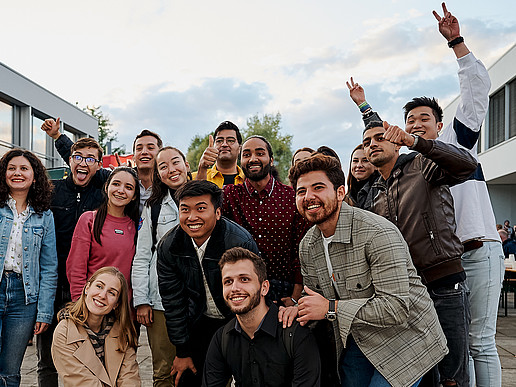 A group of students stands cheering on the Zittau campus.